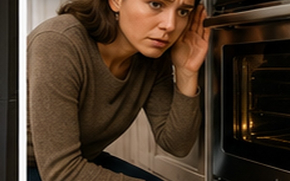 A concerned homeowner listening closely to an oven